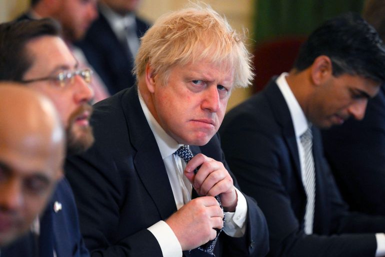 Britain's Prime Minister Boris Johnson adjusts his tie