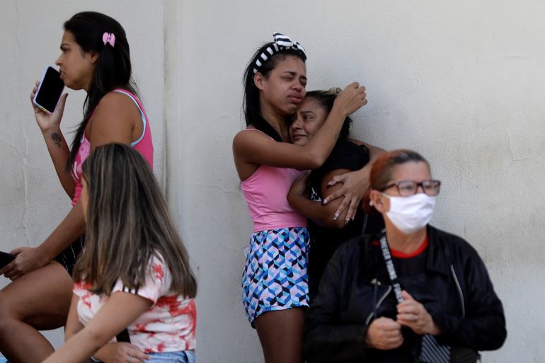 People cry as they wait outside a hospital in Brazil