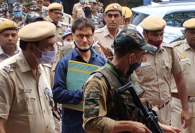 Kashmiri pro-freedom leader Yasin Malik is escorted by police officers to a court in New Delhi