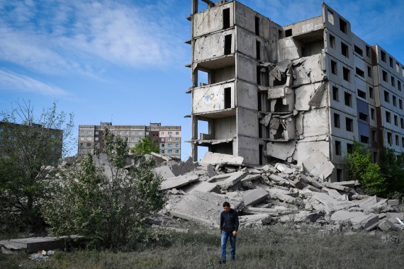 A local resident walks next to a house destroyed in a Russian shelling in Kramatorsk, Ukraine