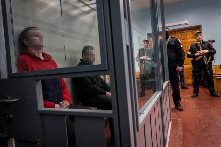 Russian soldiers Alexander Alexeevich Ivanov and Alexander Vladimirovich Bobykin, left, attend their trial hearing in Kotelva, northeastern Ukraine