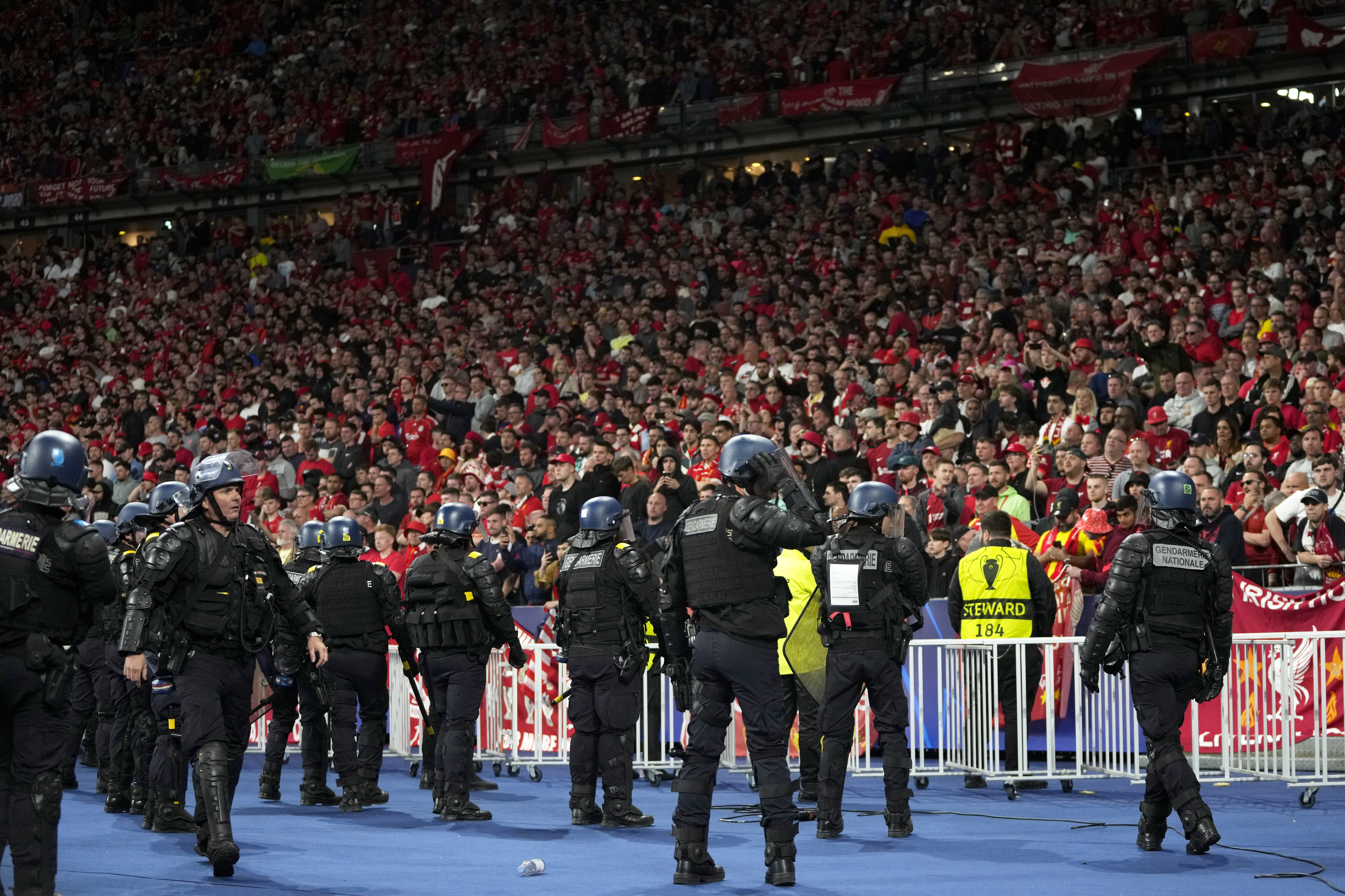 Riot police watch Liverpool fans during the Champions League final soccer match between Liverpool and Real Madrid at the Stade de France in Saint Denis near Paris