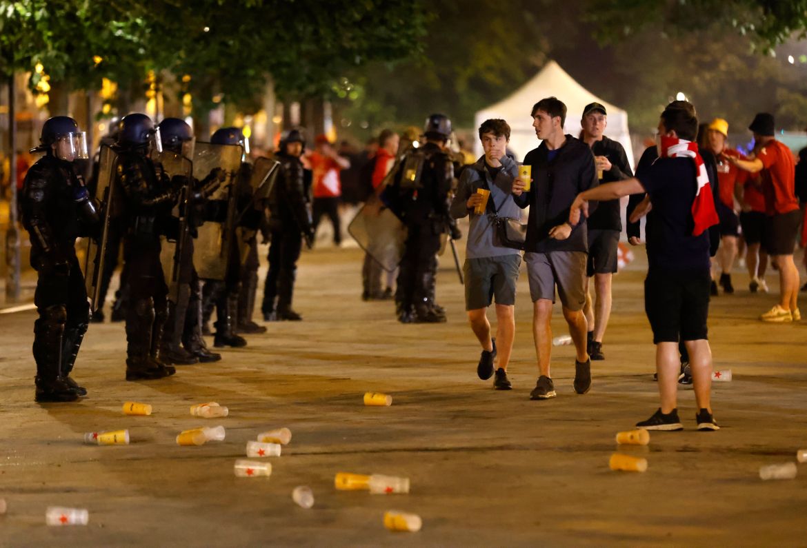 Riot police watch Liverpool fans after the Champions League final soccer match between Liverpool and Real Madrid at a fan park in Paris