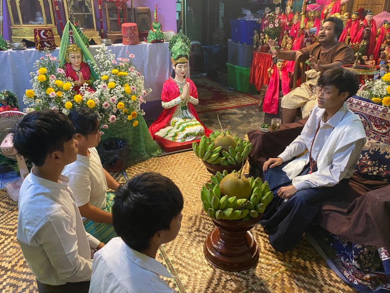 Myanmar'da bir sihirbaz öğrencilerinin önünde oturuyor
