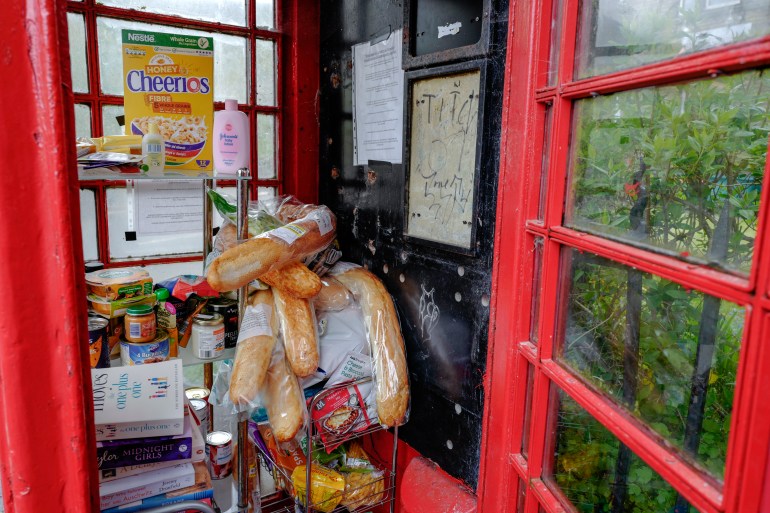 A disused traditional red phone box is converted into a free community foodbank