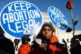 An activist holds a banner that reads "keep abortion legal" in front of the US Supreme Court
