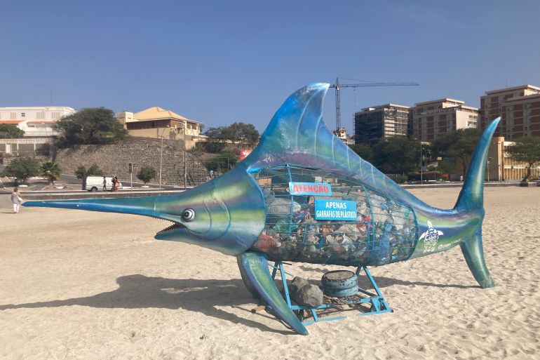 A trash can modeled after a marlin fish is seen on a beach in Mindelo, Cape Verde