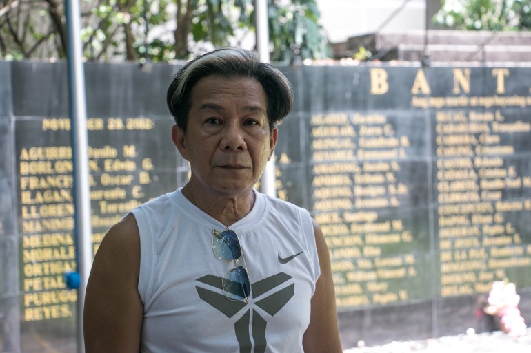 Джоуи Фаустино стоит перед мемориальной стеной жертвам военного положения.