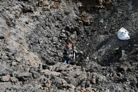 Maxim stands in the crater of an explosion after Russian shelling next to the Orthodox Skete in honour of St John of Shanghai in Adamivka, near Sloviansk, Donetsk region, Ukraine, on Tuesday, May 10, 2022 [Andriy Andriyenko/AP]