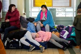 Children from Ukraine sleep on luggage at a railway station in Przemysl, southeastern Poland