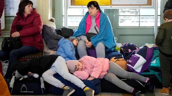 Children from Ukraine sleep on luggage at a railway station in Przemysl, southeastern Poland