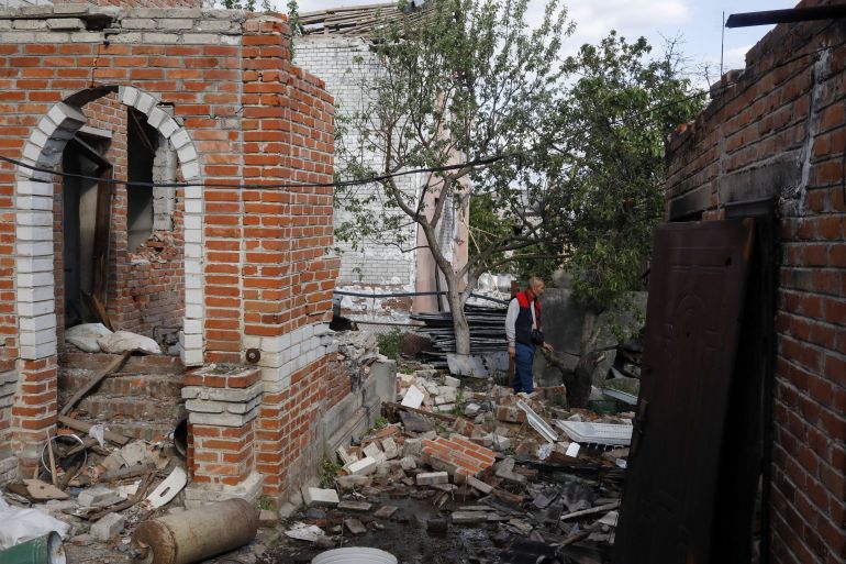 Vladimir observes his damaged house in Malaya Rohan, a village retaken by the Ukrainian forces, in Kharkiv region