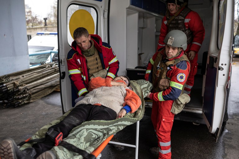 Medics transport an injured woman