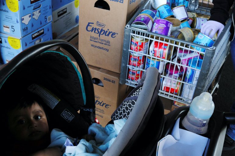 A six-month old baby rides in a stroller as his mother picks up free groceries and baby formula, amid continuing nationwide shortages in infant and toddler formula, at a food pantry run by La Colaborativa in Chelsea, Massachusetts, U.S