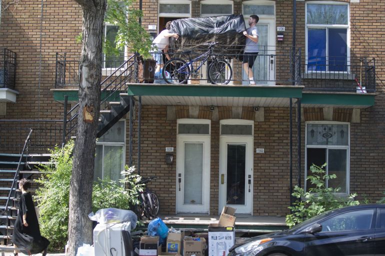 People carry down a couch out of a second floor apartment in Montreal, Quebec, Canada