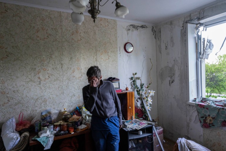 Roman Pryhodchenko cries inside his house damaged by shelling in Kharkiv.