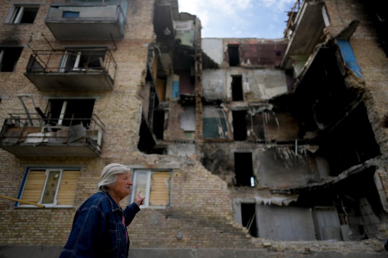A woman walks in front of a building heavily damaged by shelling in Horenka, on the outskirts of Kyiv, Ukraine.