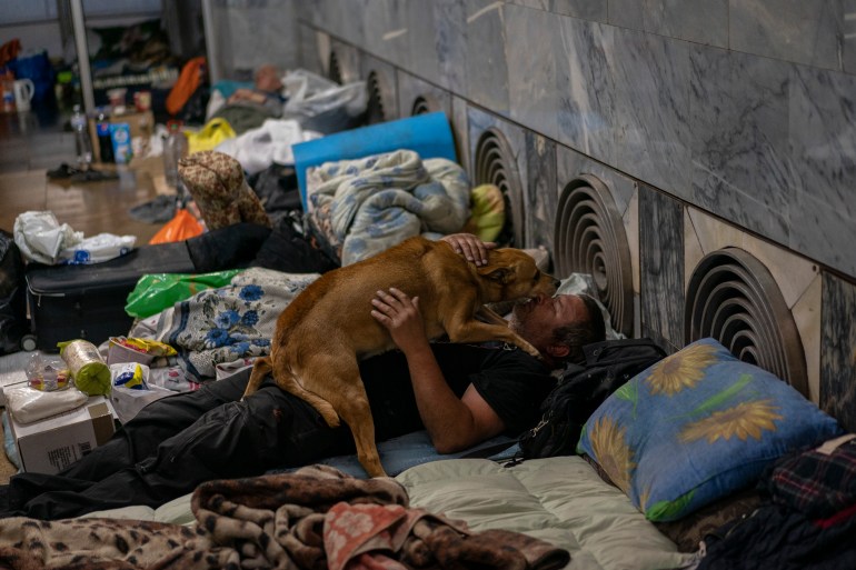 A man pets a dog in the city subway of Kharkiv, in eastern Ukraine, on Thursday, May 19, 2022.