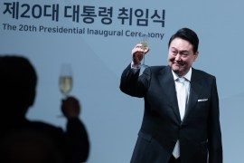 South Korea's new president Yoon Suk-yeol raises his glass from the stage during a dinner held to celebrate his inauguration