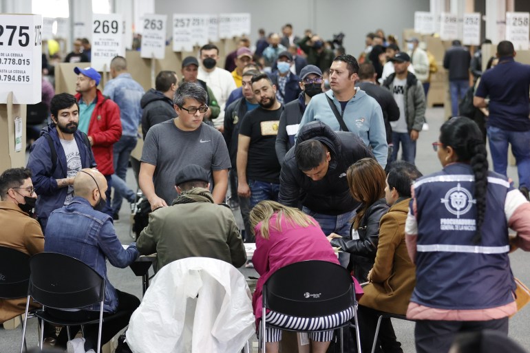 People attend to voting during the first round of presidential elections at Corferias voting centre in Bogota,