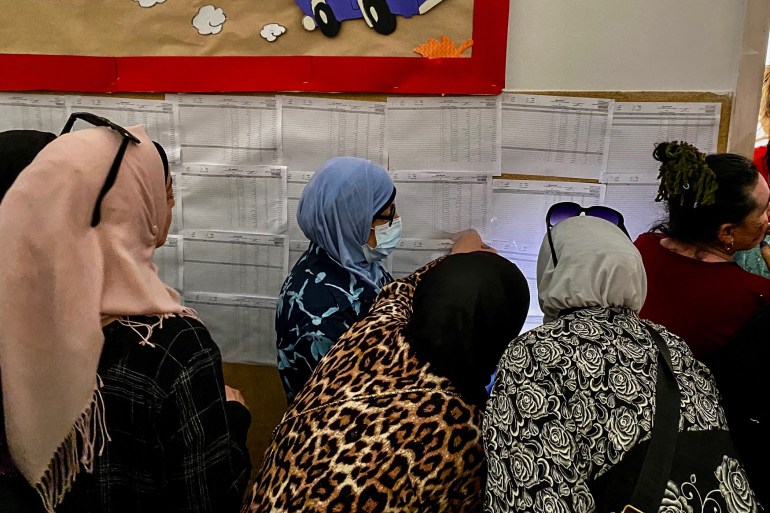Voters and staff at a polling station in a Beirut school rely on phone flashlights and battery-powered lamps due to power cuts