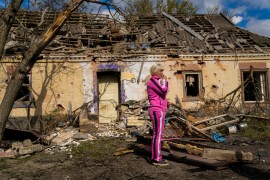 Iryna Martsyniuk, 50, stands next to her house, heavily damaged after a Russian bombing in Velyka Kostromka village, Ukraine, Thursday, May 19, 2022 [Francisco Seco/AP]