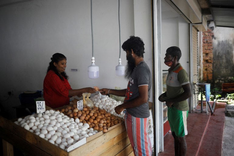 Nuwantha Kasun Jayathileke, 30, brother of Lasanda Deepthi, 43, an auto-rickshaw driver for local ride hailing app PickMe, buys eggs from a shop in Gonapola town, on the outskirts of Colombo, Sri Lanka,