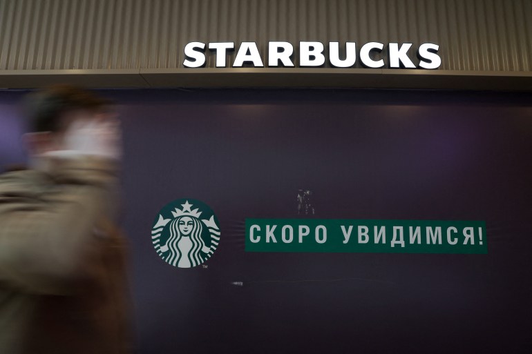 A man walks past a closed Starbucks cafe in central Saint Petersburg, Russia
