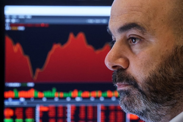 Man in front of stock charts