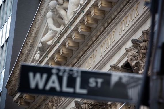A Wall Street sign in front of the New York Stock Exchange in New York City, the US.