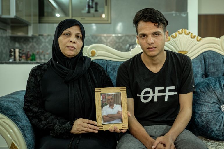 A woman and her son hold the photo of her killed husband.