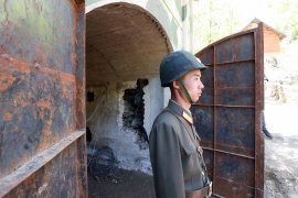 A North Korea People's Army (KPA) soldier standing at the entrance to a tunnel at the Punggye-ri nuclear test facility ahead of its demolition in 2018.