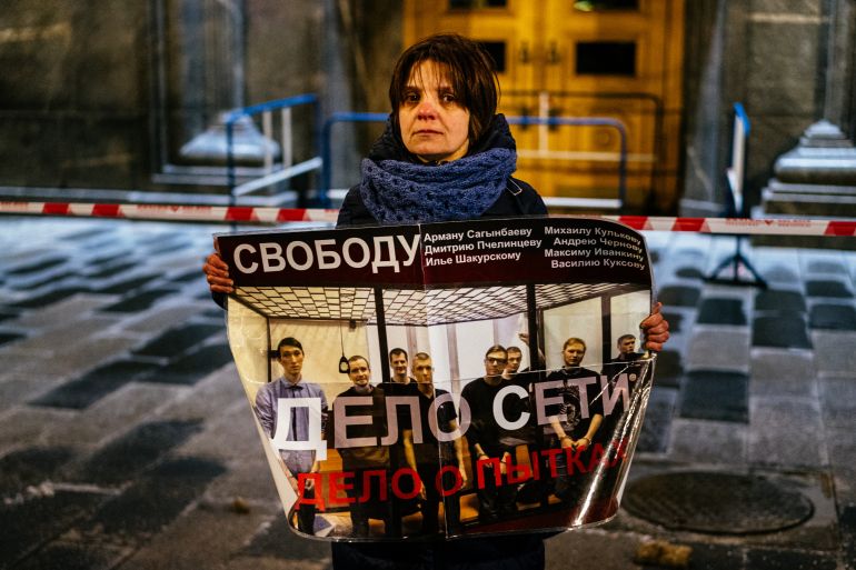 A woman holds a poster reading: "Freedom...torture case" during a protest against harsh sentences handed down to Russian anti-fascists in front of the headquarters of the FSB security services in central Moscow in 2020.
