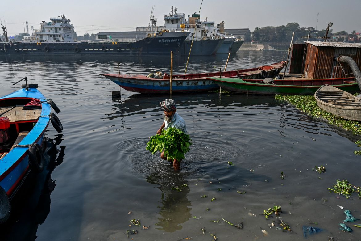 In this picture taken on March 6, 2022, a man washes vegetables in the polluted waters of the Shitolokkhya River in Narayangong.