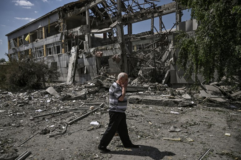A resident reacts in front of a destroyed school after an attack in the city of Bakhmut, Ukraine.