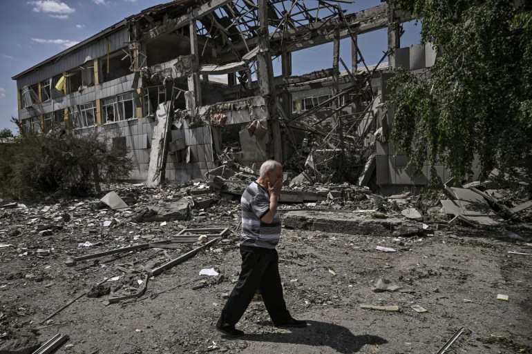 乌克兰巴赫穆特市发生袭击事件后，一名居民在一所被毁学校前做出反应。