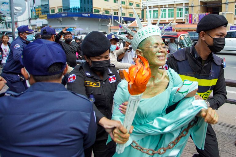 Theary Seng, dressed as 'Lady Liberty', is taken away by police after a Phnom Penh court found her gullty of 'treason'