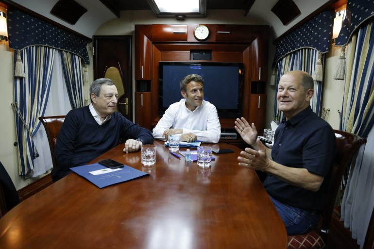 French President Emmanuel Macron (C), German Chancellor Olaf Scholz (R) and Italian Prime Minister Mario Draghi (L) travel on board a train bound to Kyiv
