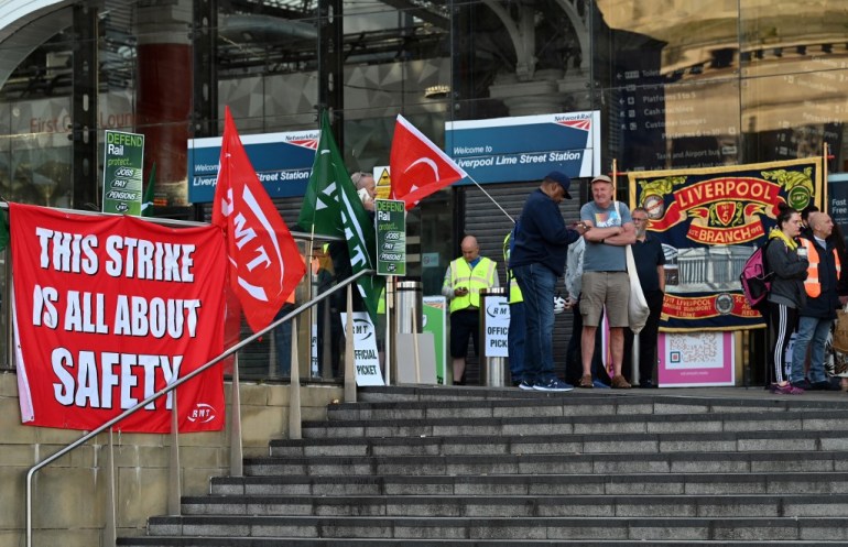 Railway workers man a picket line at Liverpool Lime Street Station