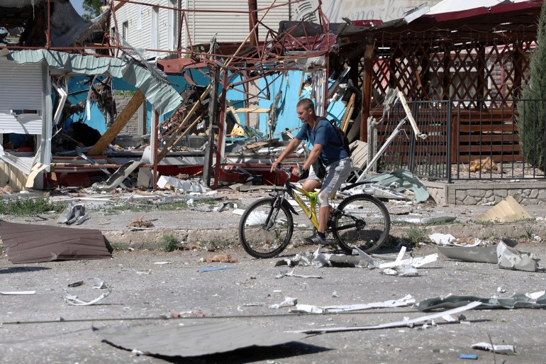 A man rides a bicycle among debris in Lysychansk, Ukraine.