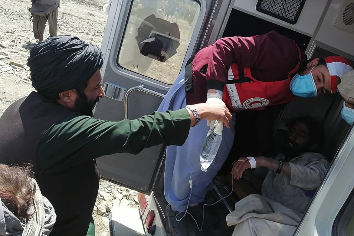 This photograph taken on June 22, 2022 and received as a courtesy of the Afghan government-run Bakhtar News Agency shows a member of the Afghan Red Crescent Society giving medical treatment to a victim following an earthquake in Afghanistan's Gayan district, Paktika province. - A powerful earthquake struck a remote border region of Afghanistan overnight killing at least 920 people and injuring hundreds more, officials said on June 22, with the toll expected to rise as rescuers dig through collapsed dwellings. (Photo by Bakhtar News Agency / AFP) / XGTY / EDITORS NOTE --- RESTRICTED TO EDITORIAL USE - MANDATORY CREDIT "AFP PHOTO /Bakhtar News Agency " - NO MARKETING - NO ADVERTISING CAMPAIGNS - DISTRIBUTED AS A SERVICE TO CLIENTS - NO ARCHIVE