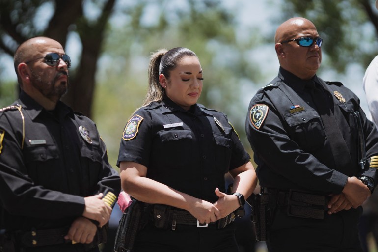 Un ofițer al departamentului de poliție Uvalde, care stă lângă șeful poliției Uvalde CISD, Pete Arredondo, reacționează în timpul unei conferințe de presă în Uvalde, Texas.