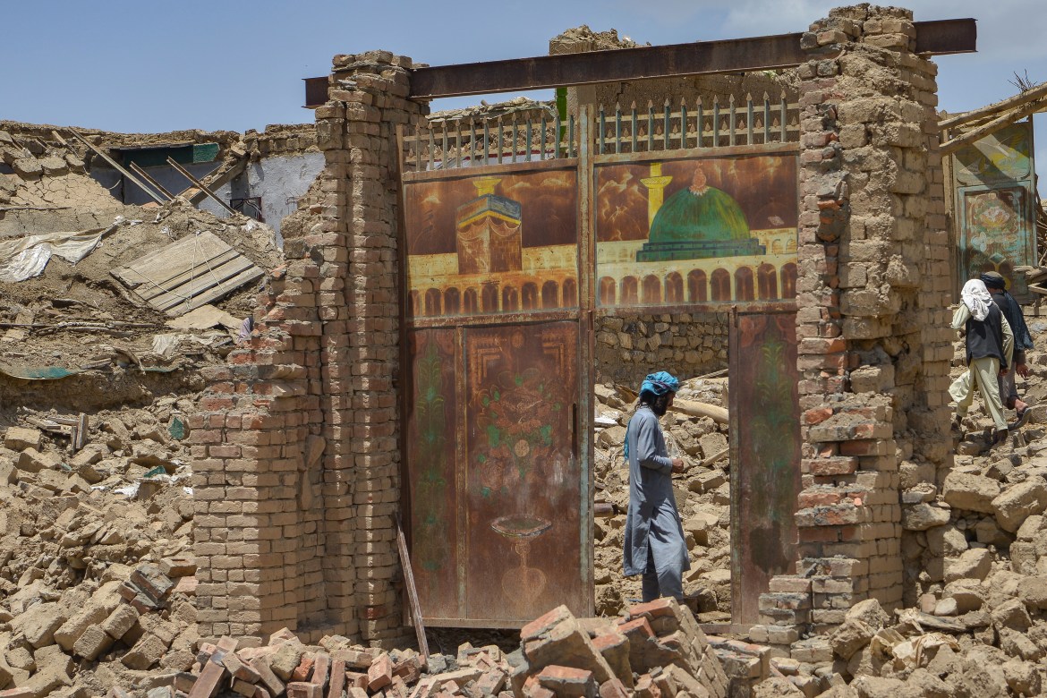 An Afghan man stands besides a door of a house damaged by an earthquake in Bernal district, Paktika province,