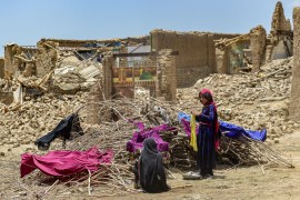 Afghan people keep their clothes to dry on dried out shrubs near the ruins of houses damaged by an earthquake in Bernal district, Paktika provin