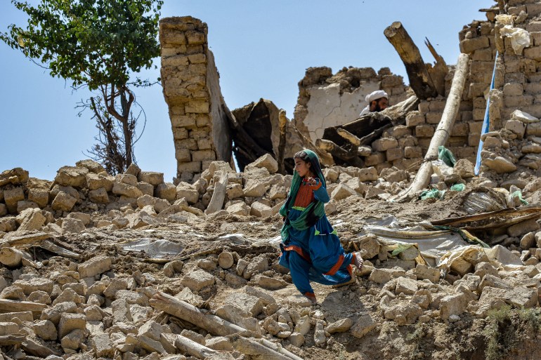 A child walks amid the rubble of damaged houses following an earthquake in Bernal district, Paktika.