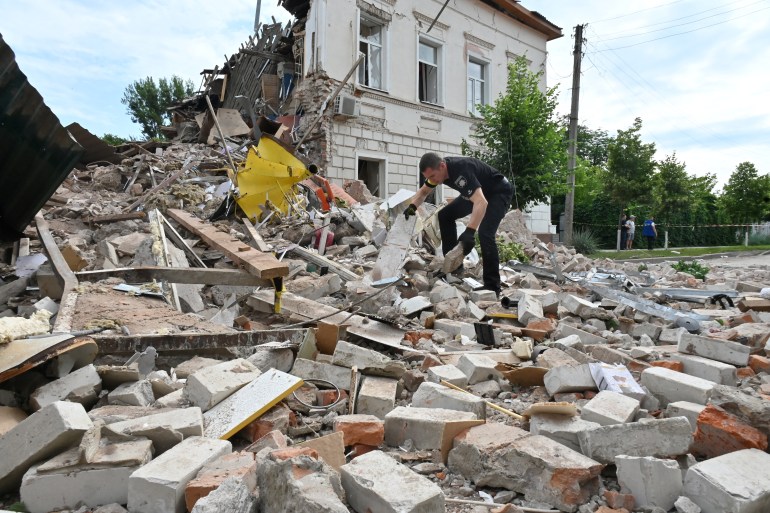 A policeman searches through the wreckage of a building after the explosion of a Russian rocket