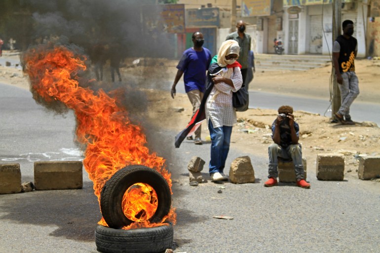 Sudanese anti-coup protesters burn tyres amid clashes with security forces in Omdurman, the capital Khartoum's twin city, on June 30, 2022 [AFP]