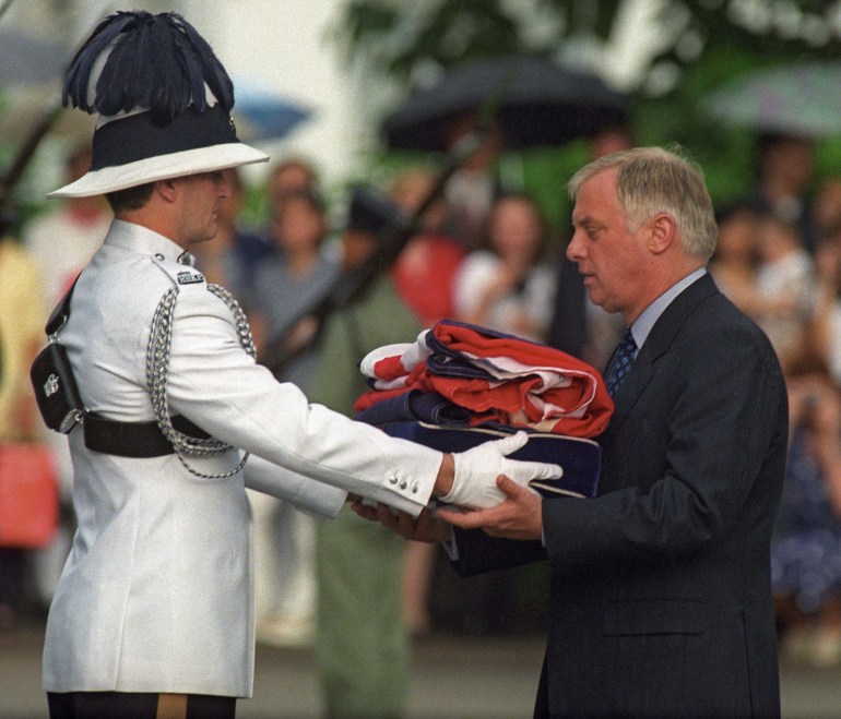 Chris Patten receives the Union Jack flag after is was lowered for the last time.