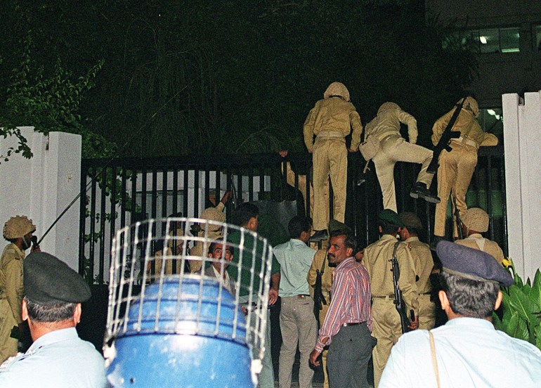 (ARCHIVOS) En esta imagen tomada el 12 de octubre de 1999, los soldados del ejército de Pakistán ingresan al edificio de la televisión estatal saltando la puerta en Islamabad.