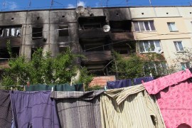 Drying laundry near a shelling-damaged apartment building in Makariv,